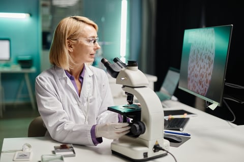 Female scientist examining samples under microscope