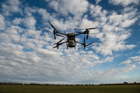 Agricultural drone spreading fertilizer on a newly planted field