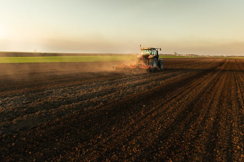 Farmer preparing his field in a tractor ready for spring