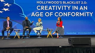 Panel discussion on stage with four speakers seated on stools discussing Hollywoods Blacklist 2.0: Creativity in an Age of Conformity