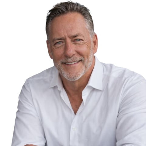Middle-aged man with gray hair wearing a white button-up shirt against a white background, smiling at camera